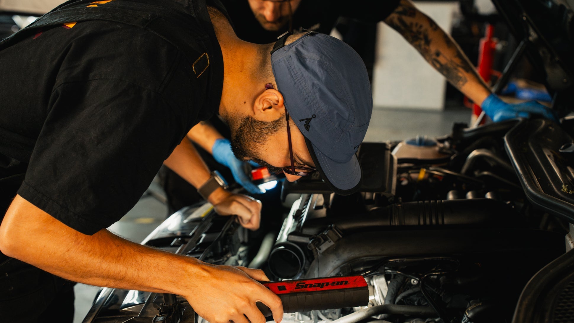 Mechanic working on a car engine with tools